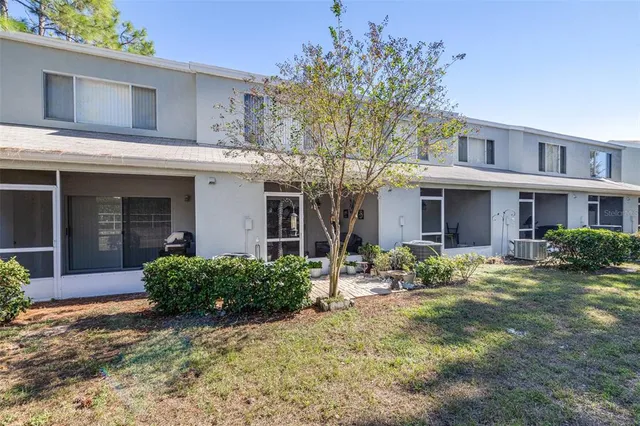 a view of a house with potted plants and a table and chairs