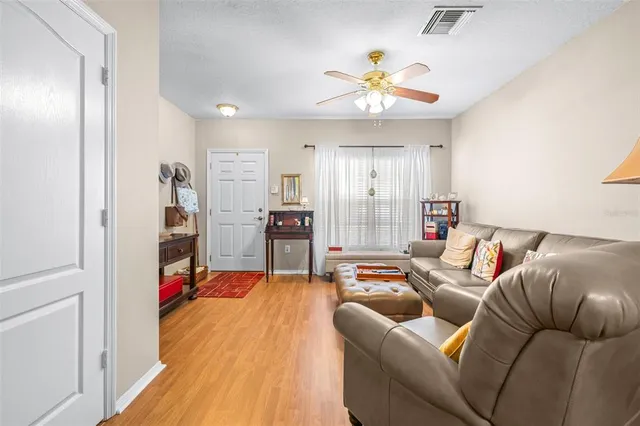 a living room with furniture kitchen view and a chandelier