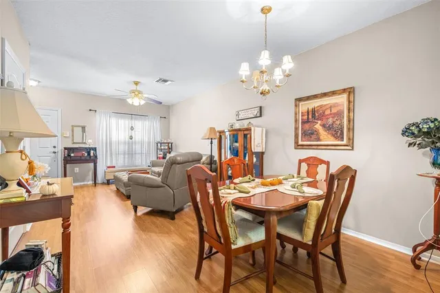 a view of a dining room with furniture a chandelier and wooden floor