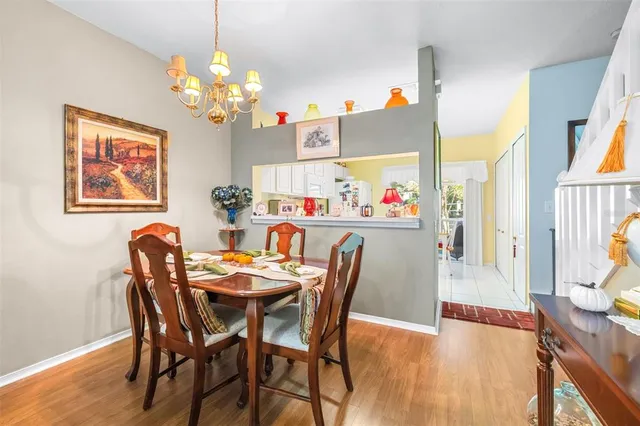 a dining room with furniture a chandelier and wooden floor