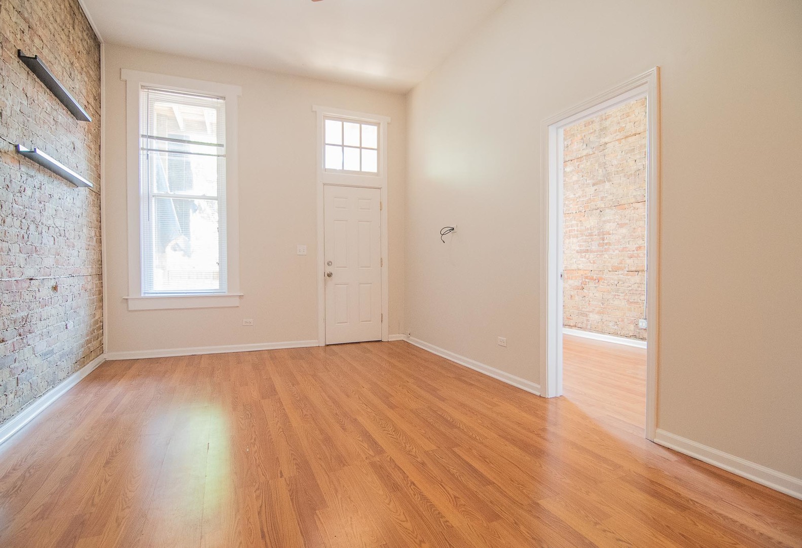 1475 West Huron Street, Unit 1R Chicago, IL 60642 - Photo 3 of 8 an empty room with wooden floor and windows
