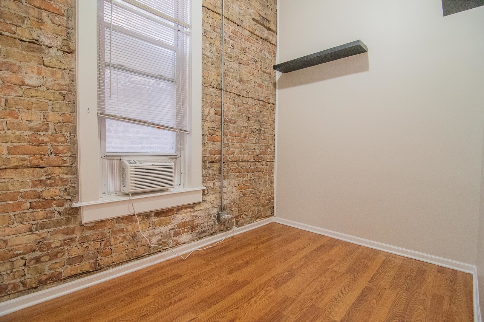 1475 West Huron Street, Unit 1R Chicago, IL 60642 - Photo 5 of 8 a view of a small space with wooden floor and a window