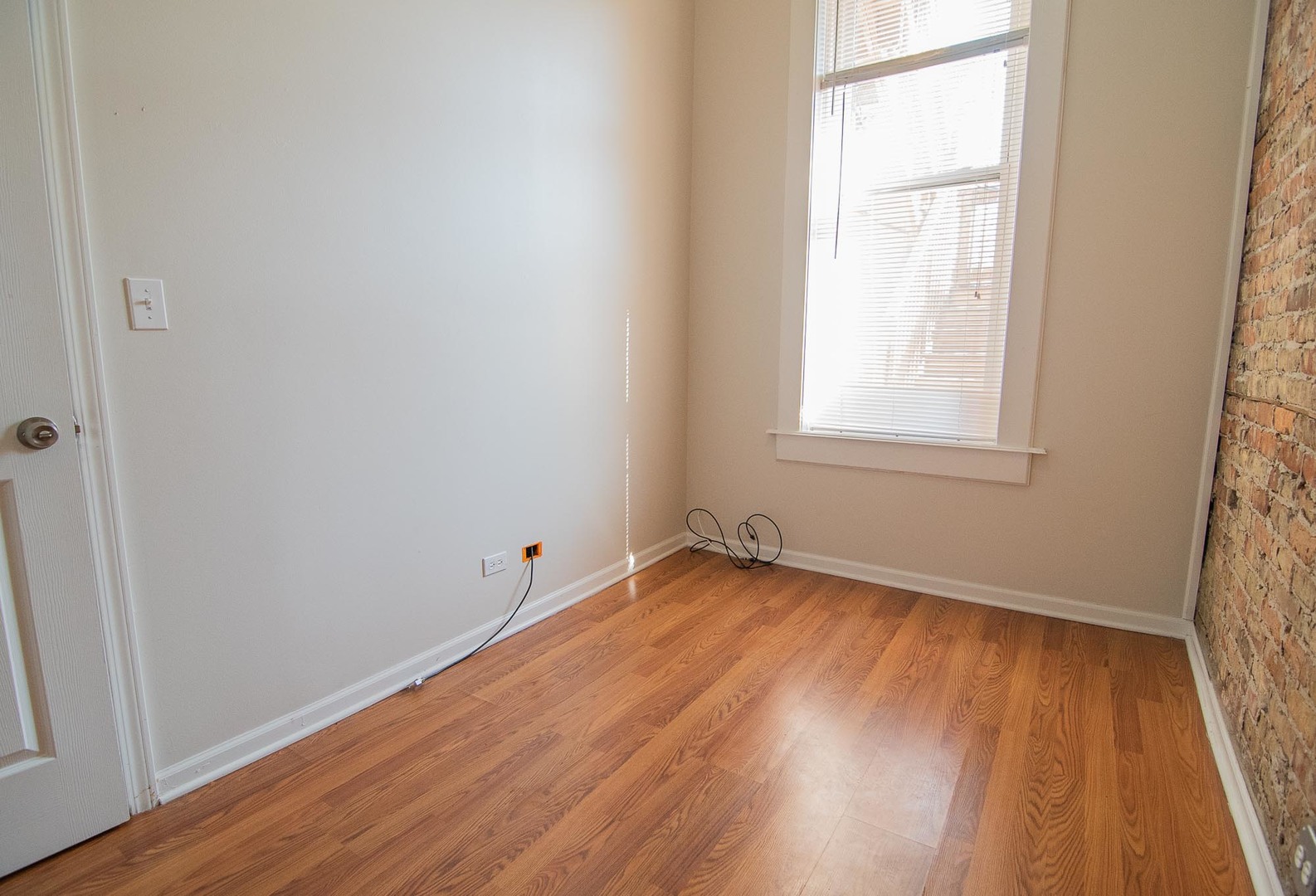 1475 West Huron Street, Unit 1R Chicago, IL 60642 - Photo 6 of 8 an empty room with wooden floor and windows