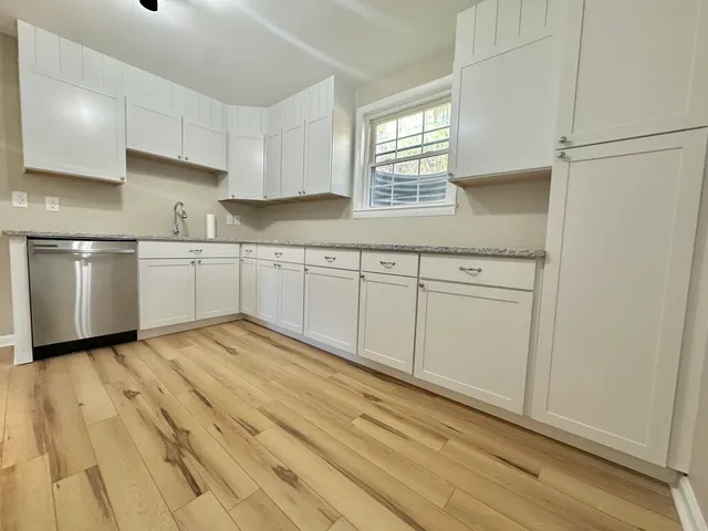 a kitchen with granite countertop white cabinets and white appliances