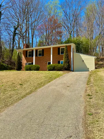 a view of a house with a yard and tree