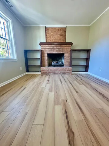 wooden floor a fireplace and windows in a room