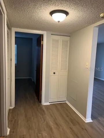 an empty room with wooden floor and closet