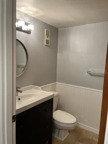 a bathroom with a sink a toilet and a mirror