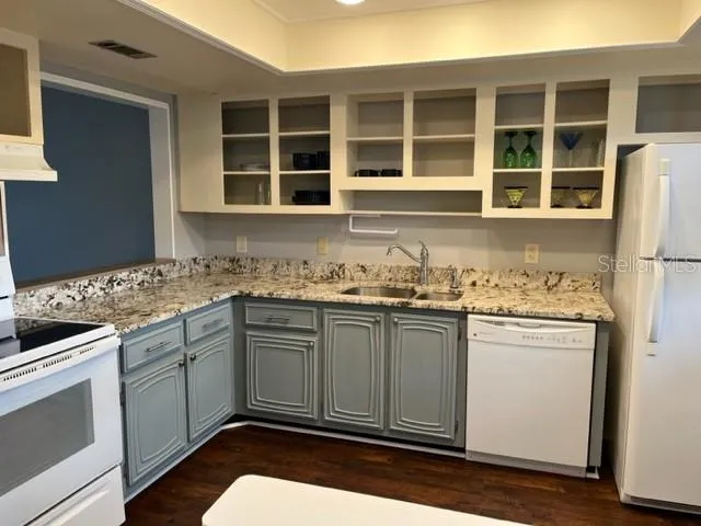 a kitchen with granite countertop cabinets stainless steel appliances and a sink