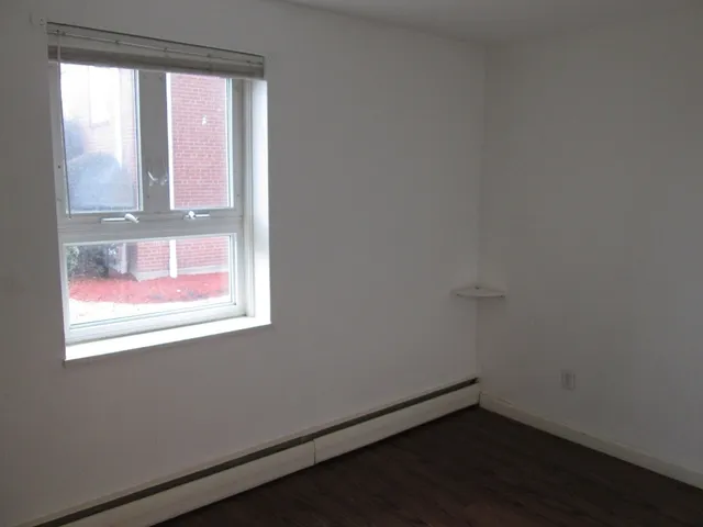 a view of a small space with wooden floor and a window