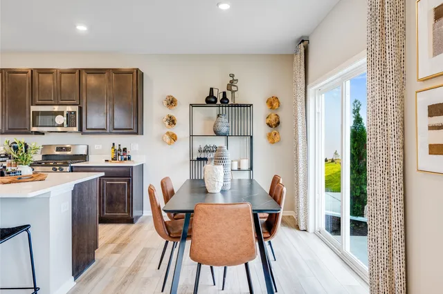 a kitchen with stainless steel appliances granite countertop a refrigerator and a dining table
