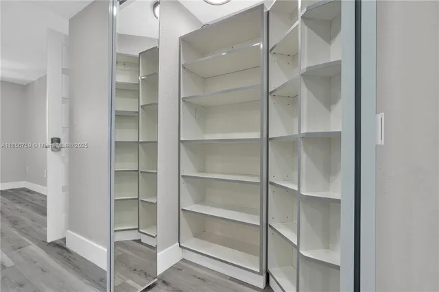 a view of walk in closet with empty racks