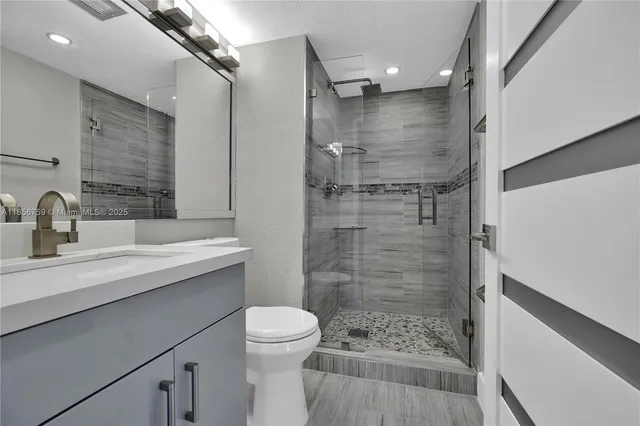 a bathroom with a sink shower and a toilet