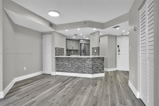 wooden floor in an empty room with a kitchen
