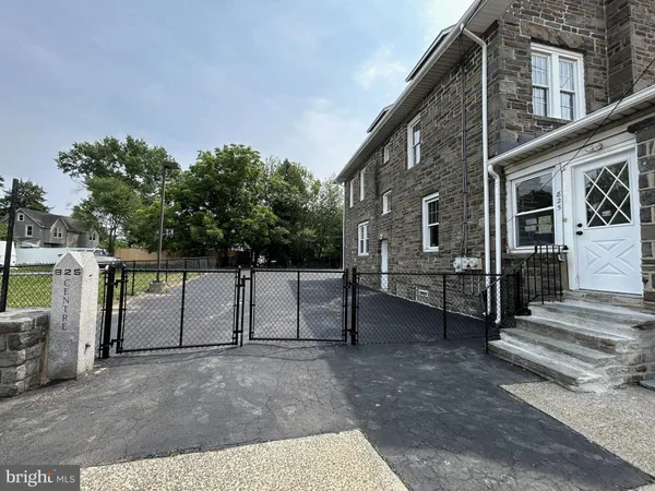 a view of a house with backyard and parking