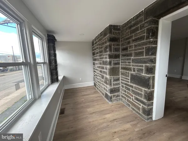 a view of empty room with wooden floor and fireplace