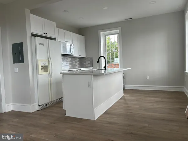 a kitchen with a sink and wooden floor