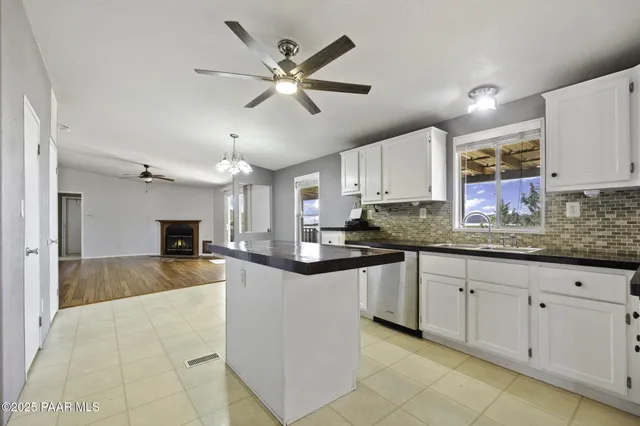a kitchen with stainless steel appliances kitchen island granite countertop a refrigerator a stove top oven a sink and dishwasher