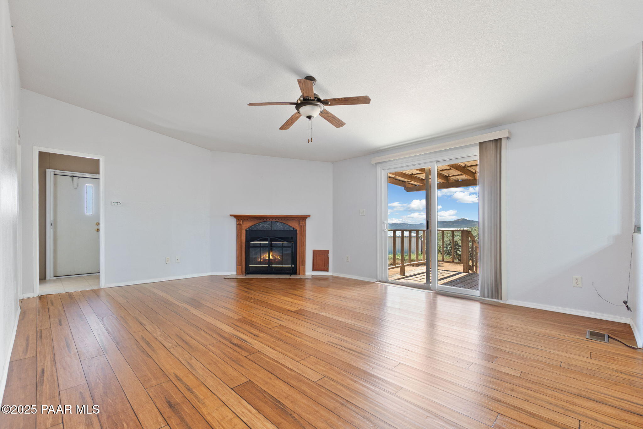 18125 East Roper Way Dewey, AZ 86327 - Photo 18 of 63 a view of an empty room with wooden floor fireplace and a window