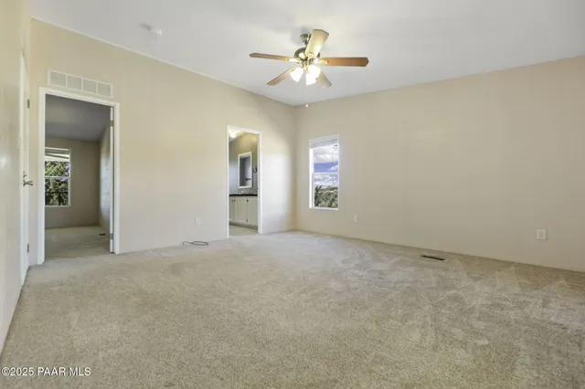 a living room with furniture and a window with a bookshelf