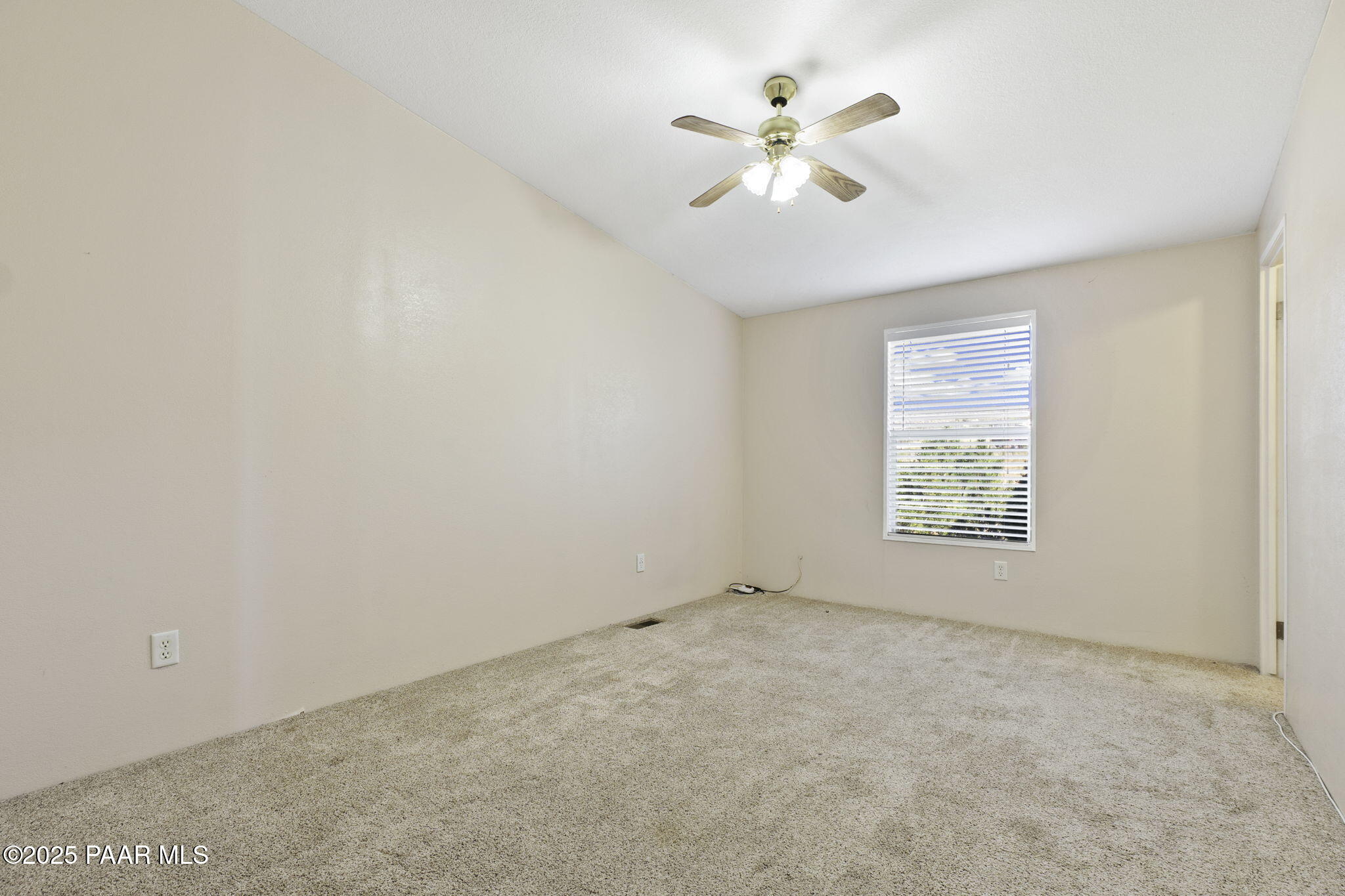 18125 East Roper Way Dewey, AZ 86327 - Photo 38 of 63 an empty room with a chandelier fan and windows