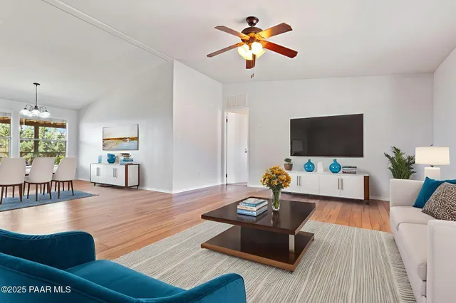 a view of empty room with wooden floor and fan