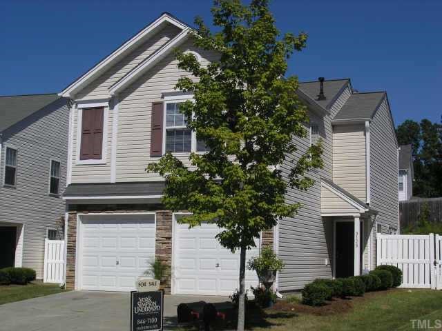 a front view of a house with a tree
