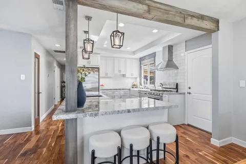 a dining hall with stainless steel appliances kitchen island granite countertop a refrigerator and microwave