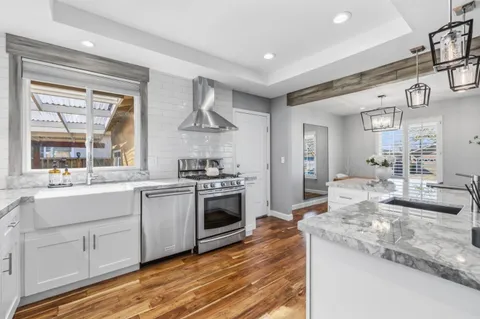 a large kitchen with granite countertop a stove and a sink