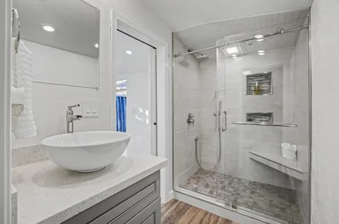 a bathroom with a granite countertop sink a toilet and shower