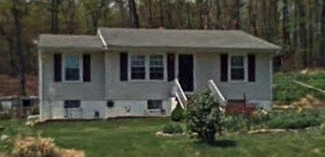 a view of a house with brick walls and a yard with plants