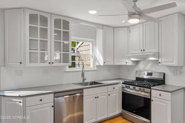 a kitchen with granite countertop white cabinets stainless steel appliances and a sink