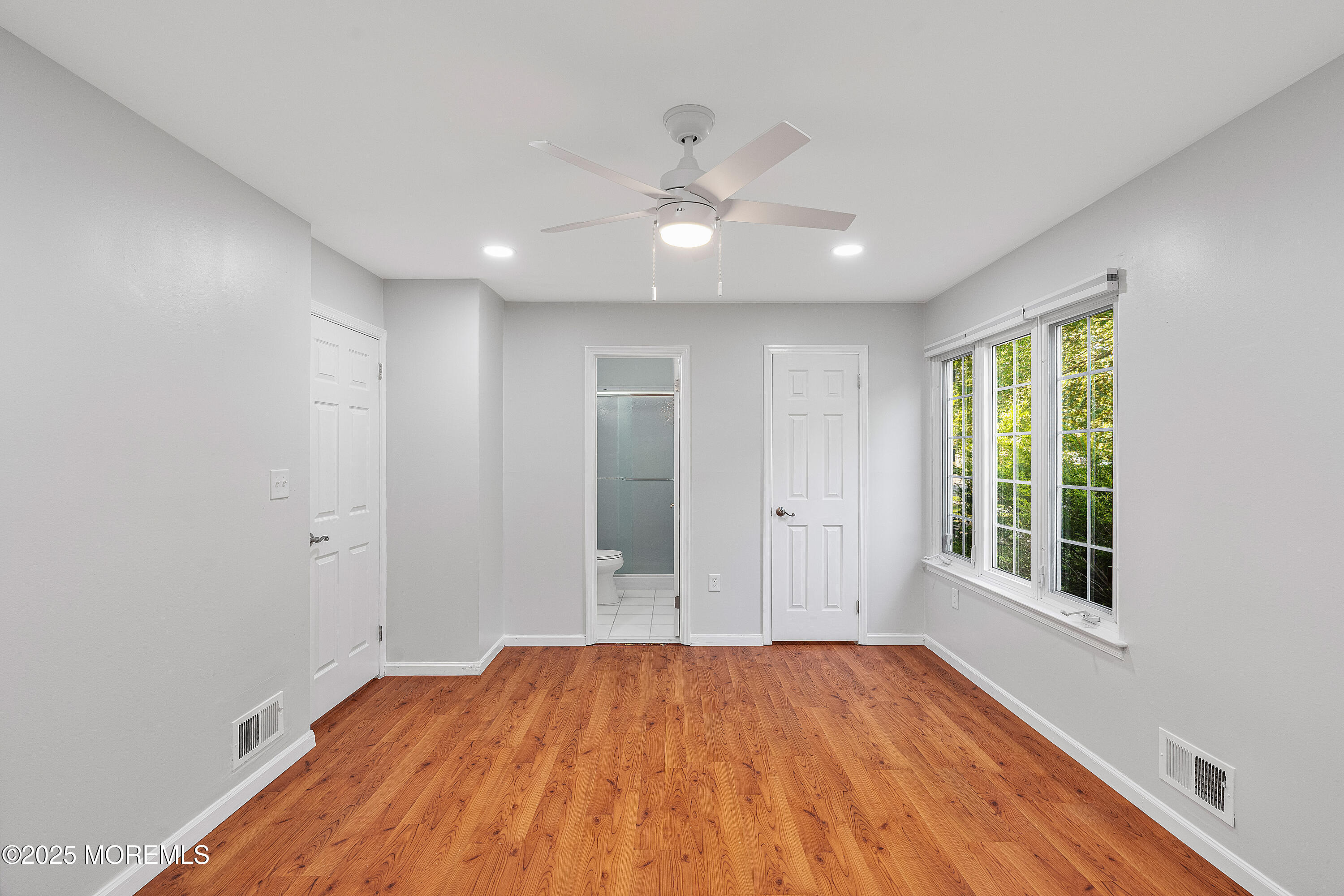 61 Berkshire Drive Howell, NJ 07731 - Photo 30 of 43 a view of empty room with wooden floor and fan