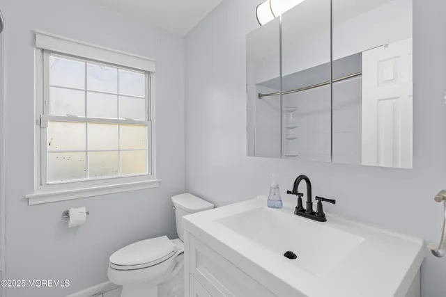 a bathroom with a sink toilet and mirror