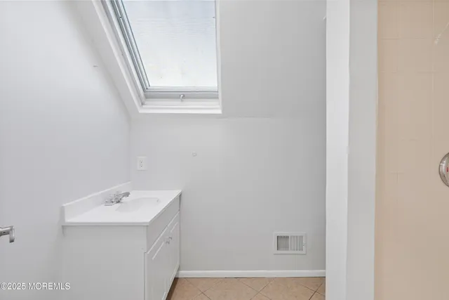 a bathroom with a sink a window and a mirror