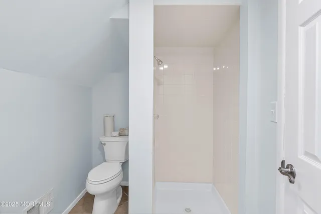 a white toilet sitting next to a shower