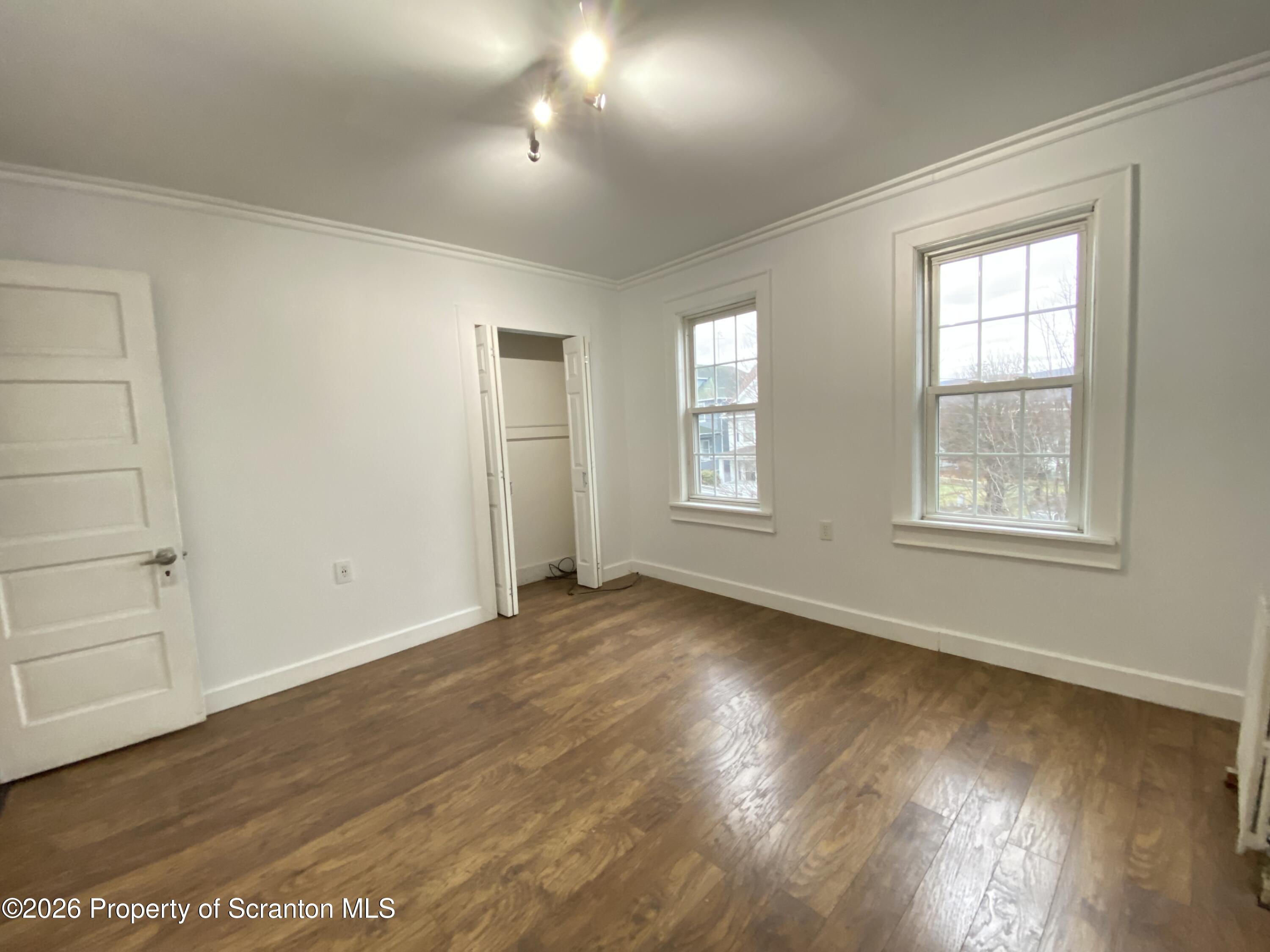 1827 Prospect Avenue Scranton, PA 18505 - Photo 31 of 48 an empty room with wooden floor and windows