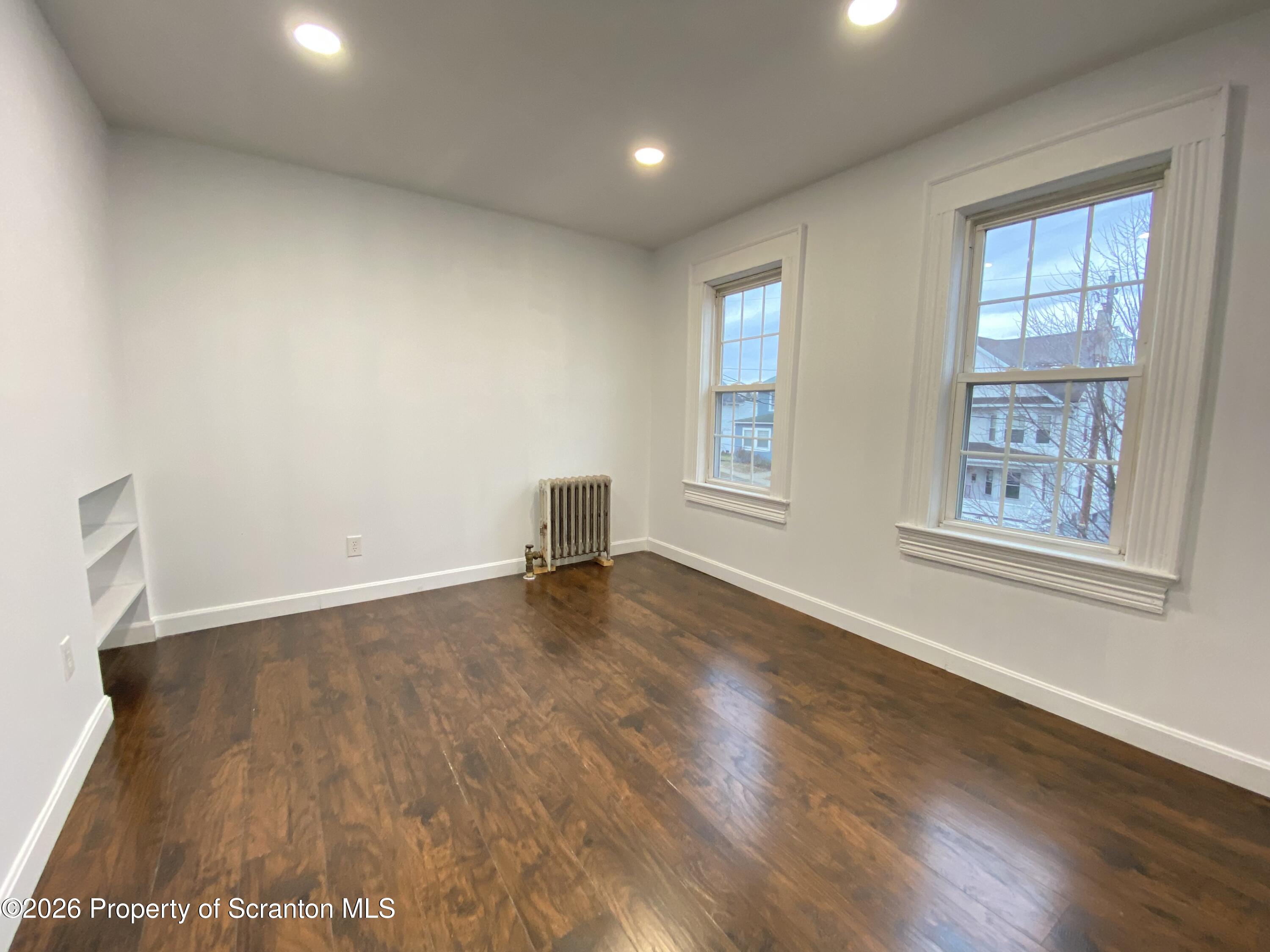 1827 Prospect Avenue Scranton, PA 18505 - Photo 32 of 48 an empty room with wooden floor and windows