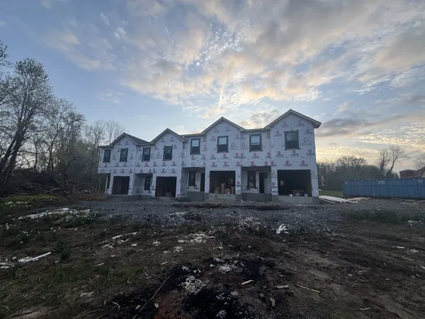 a view of a big house with a big yard and large trees