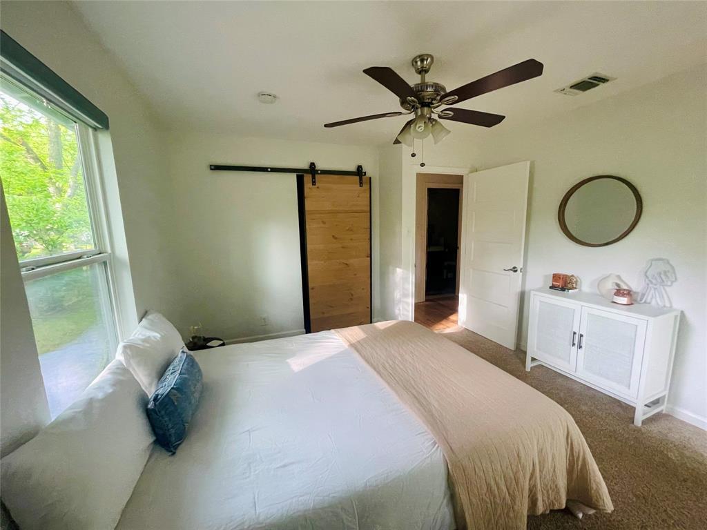 3208 Thompson Street Austin, TX 78702 - Photo 8 of 16 a bedroom with a bed and a chandelier