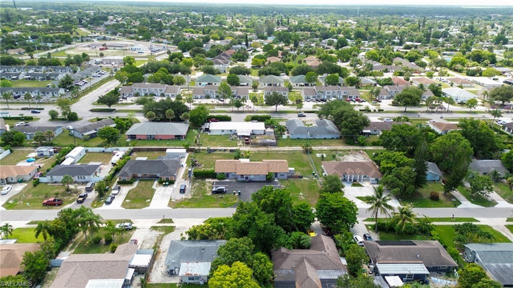 1940 48th Street Southwest Naples, FL 34116 - Photo 12 of 33 Aerial perspective showcasing a residential area with varied single-story homes, mature trees, and paved streets