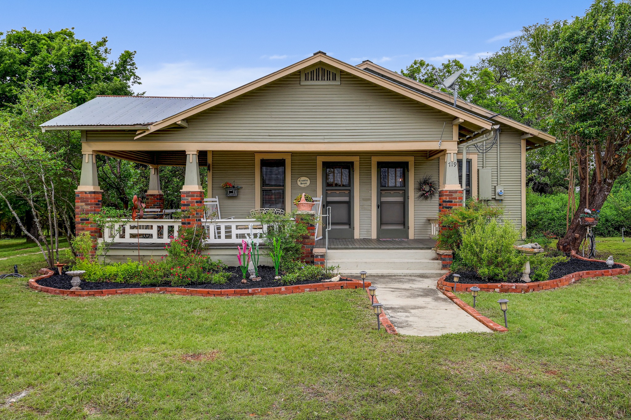 719 Elm Street Blanco, TX 78606 - Photo 2 of 25 Craftsman-style home featuring a covered front porch with brick column bases and a metal roof