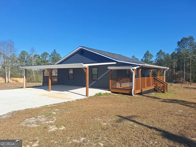 a view of a house with a yard and wooden fence