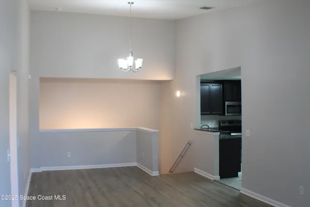 an empty room with wooden floor and cabinet