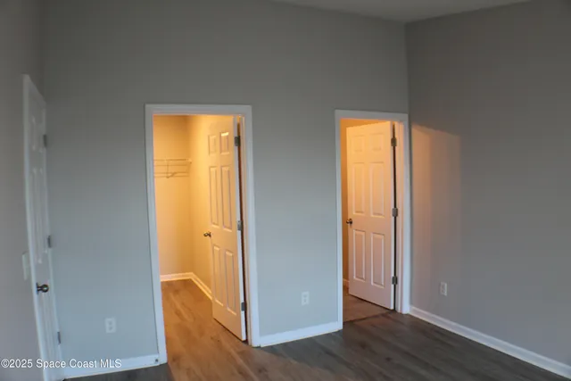 an empty room with wooden floor and door