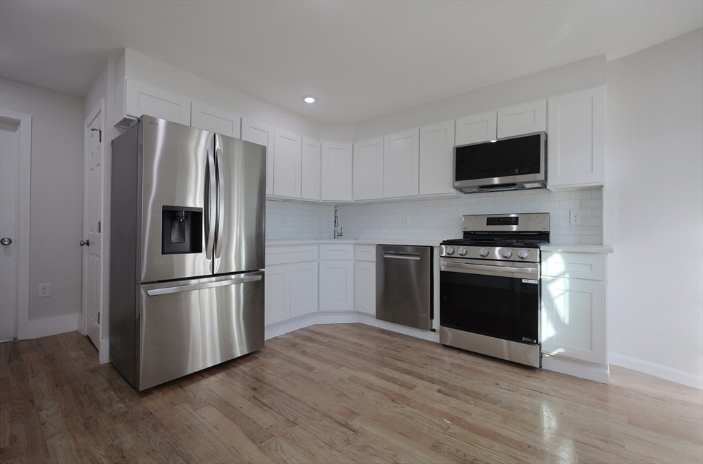 3 Appian Place Boston, MA 02128 - Photo 2 of 15 a kitchen with stainless steel appliances a refrigerator microwave and sink