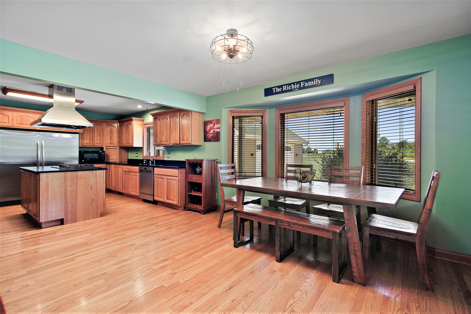 2068 East 7750S Road Chebanse, IL 60922 - Photo 8 of 24 a kitchen with stainless steel appliances kitchen island granite countertop a stove a refrigerator a dining table and chairs with wooden floor