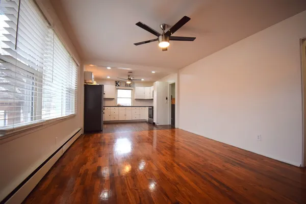 a view of a livingroom with a ceiling fan and wooden floor