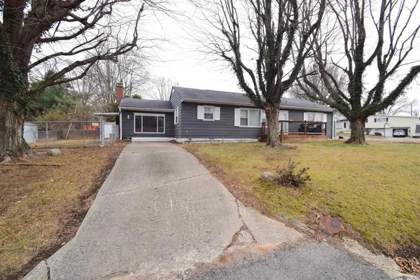 a front view of a house with a yard and trees
