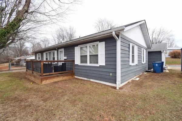 a view of backyard with deck and wooden fence